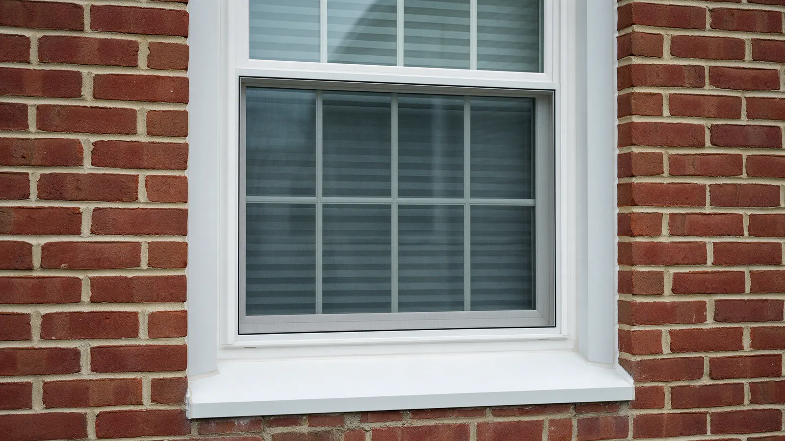 New double-hung window set in a brick wall with clean trim and a sealed sill